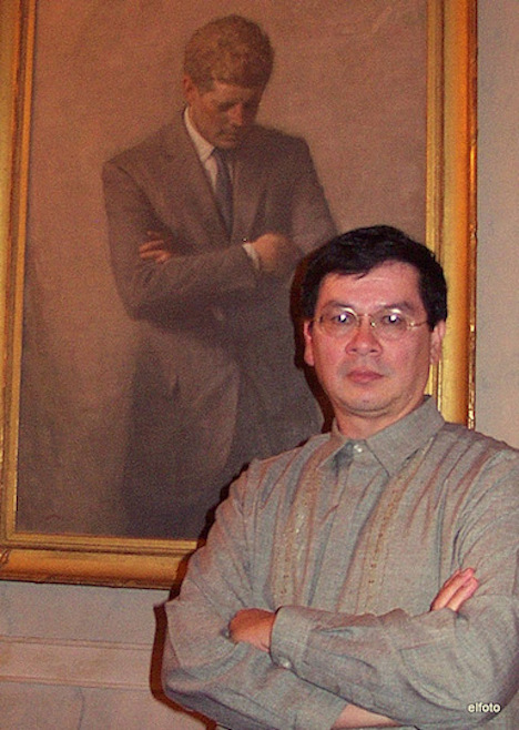 The author strikes wistful pose under a portrait of President John F. Kennedy in the White House.