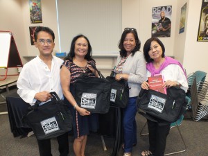 Speakers receive the  35th Anniversary Book Bags from event co-sponsor Asian /Pacific American Librarians Association (APALA) from left:  Jaime Geaga, program emcee, Cindy Domingo, speaker, Mila DeGuzman, author, and Roselyn Ibanez, moderator.