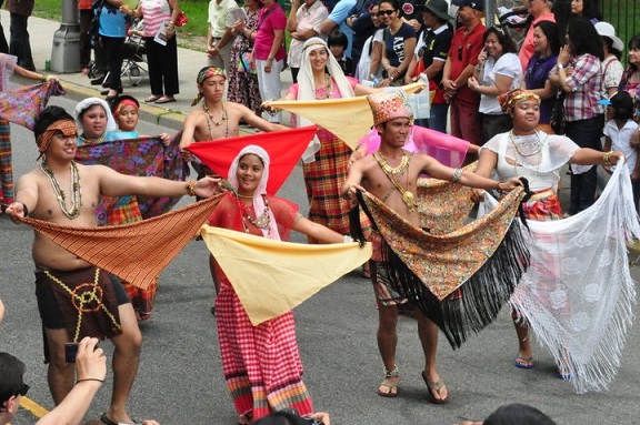 Filipinos perform a traditional dance at a cultural day parade. Photo by Elton Lugay