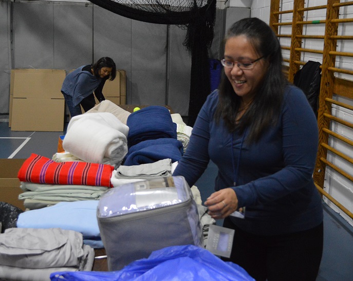 The author leads community volunteers in sorting and folding  donated bed sheets and linens 