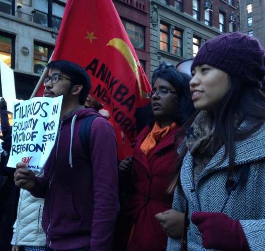 Members of Anakbayan hold ‘Filipinos stand with Ferguson’ sign