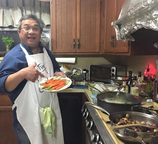 Boyet about to toss the baby carrots into the steaming pan.