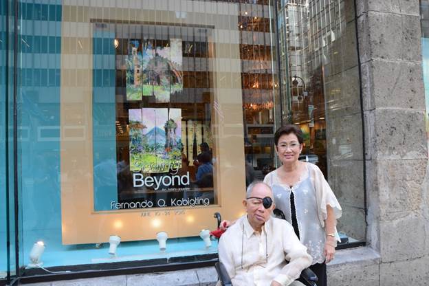 The artist with wife Menchu outside the Philippine Center Gallery, where the window display featured two of his pieces depicting the Paoay Church and Mt. Mayon.   