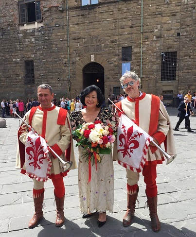 Behind Lolita is the Palazzo Vecchio, as she stands flanked by Florentine men in medieval costumes.