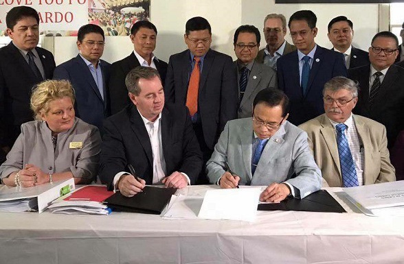 Iglesia Ni Cristo officials and Johnsonville representatives  ink $1.85 million purchase agreement. East Haddam First Selectman Emmett Lyman, seated at far right, is witness to the signing. 