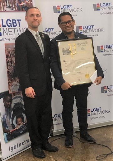 Elton Lugay receives a plaque of appreciation from New York State Assembly Member Brian Barnwell