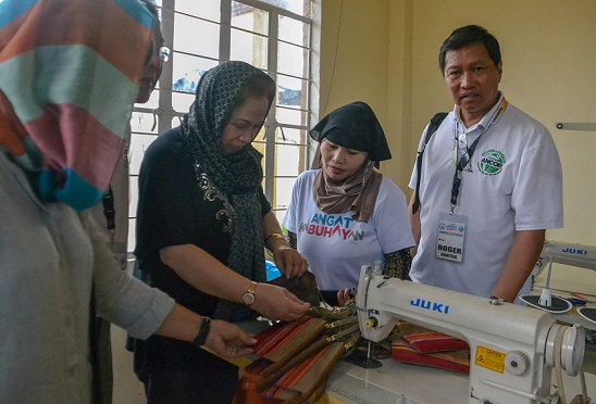 ANCOP USA President Roger Santos and wife Josie Santos (in black clothing) check high-speed sewing machines donated for the refugees’ livelihood. 