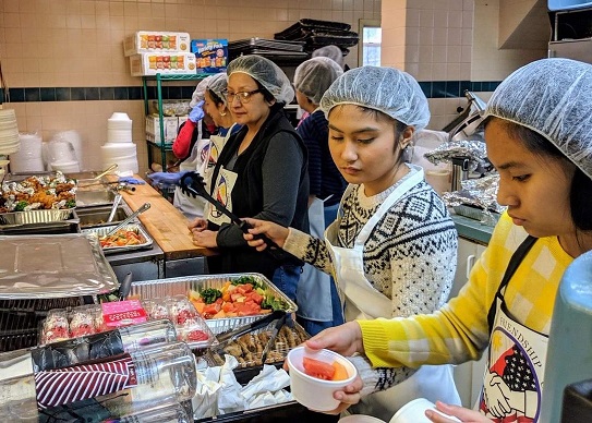 Taino sisters Krismarie, 15, (in white sweater) and Marykirsten, 14, were among the young volunteers who served up Filipino food on Presidents Day.